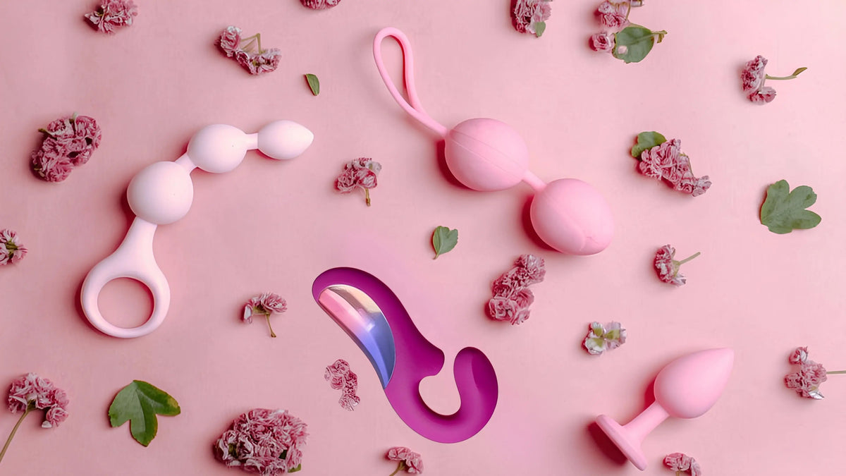 Pink adult intimate toys and accessories flat lay with delicate flowers