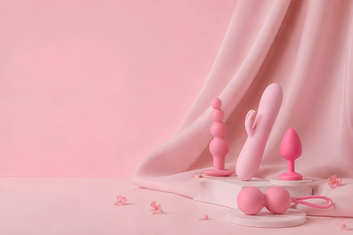Collection of pink pleasure toys on podium with draped soft fabric